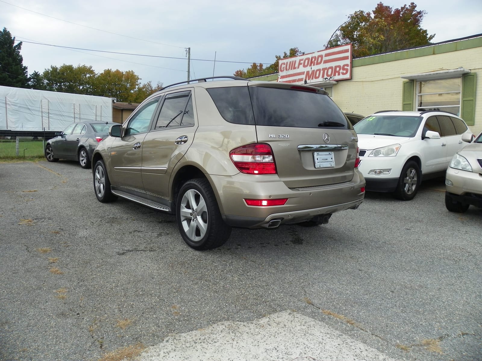 The real Guilford Motors lot on West Market — the red GUILFORD MOTORS sign on the building behind the gold ML 320